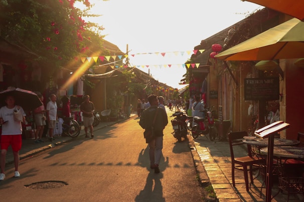 A cozy village street bustling with locals and tourists during a colorful festival