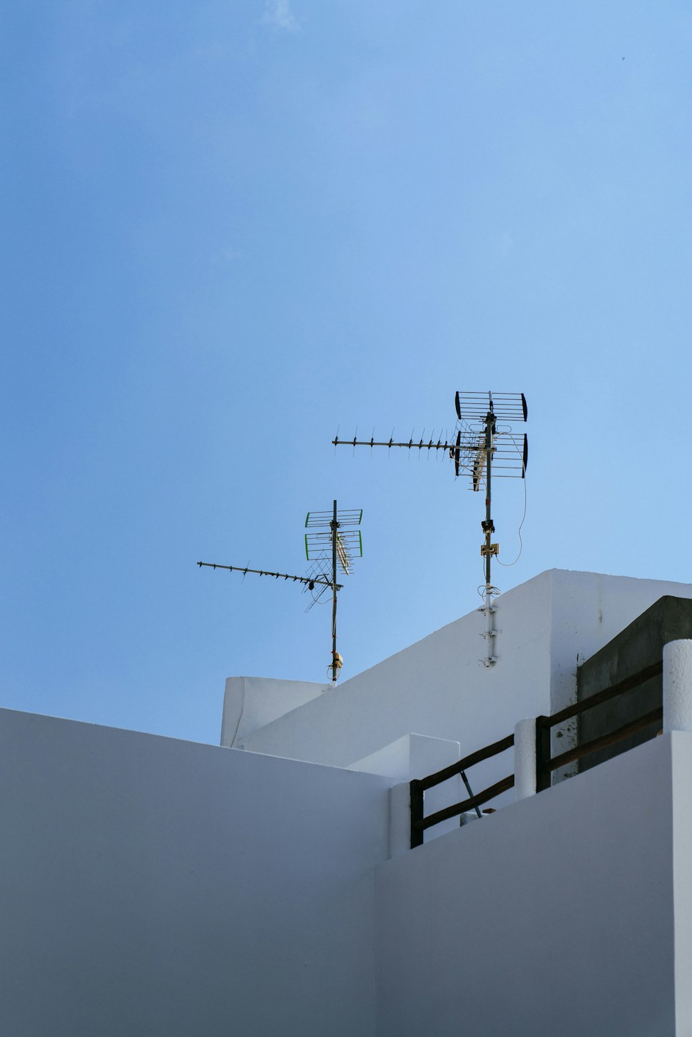 Deux antennes brunes sur un bâtiment en béton