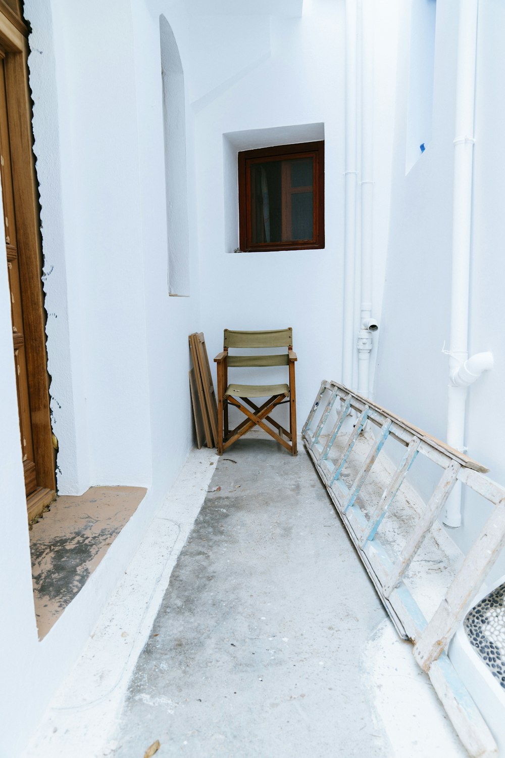 a wooden chair sitting in a room next to a window