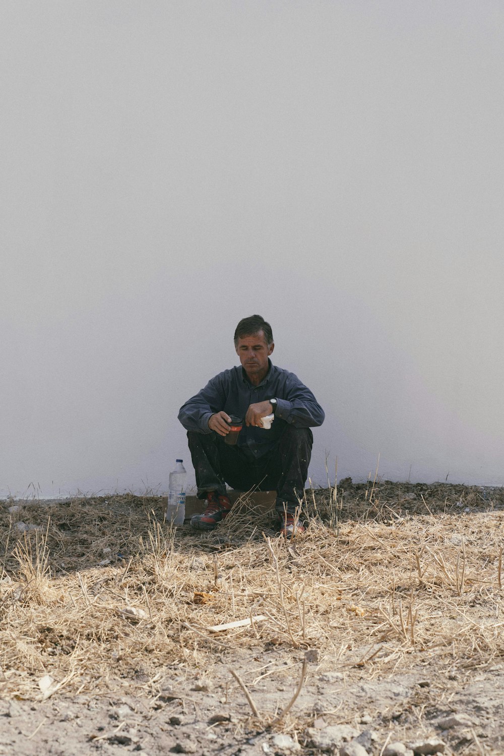 man leaning on white wall