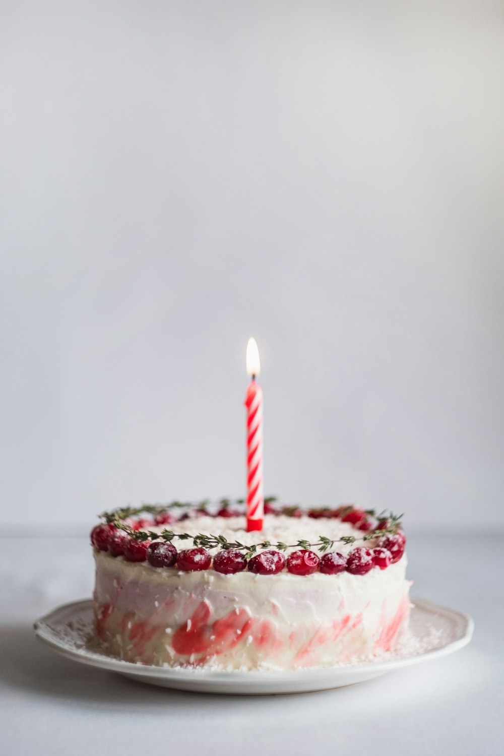 gâteau recouvert de blanc et rose avec bougie allumée