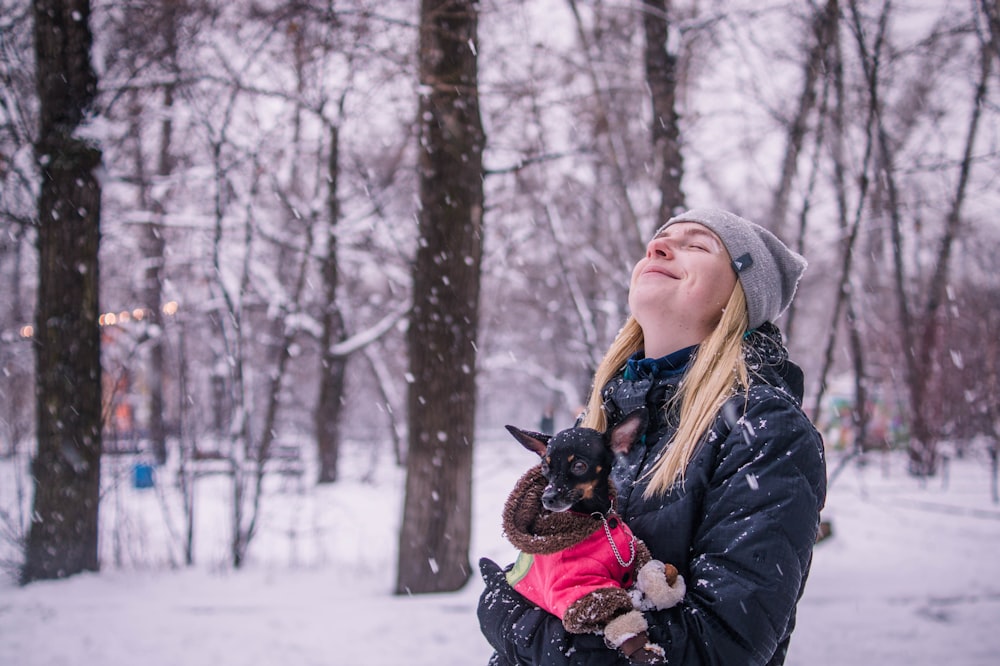 woman holding dog while looking up