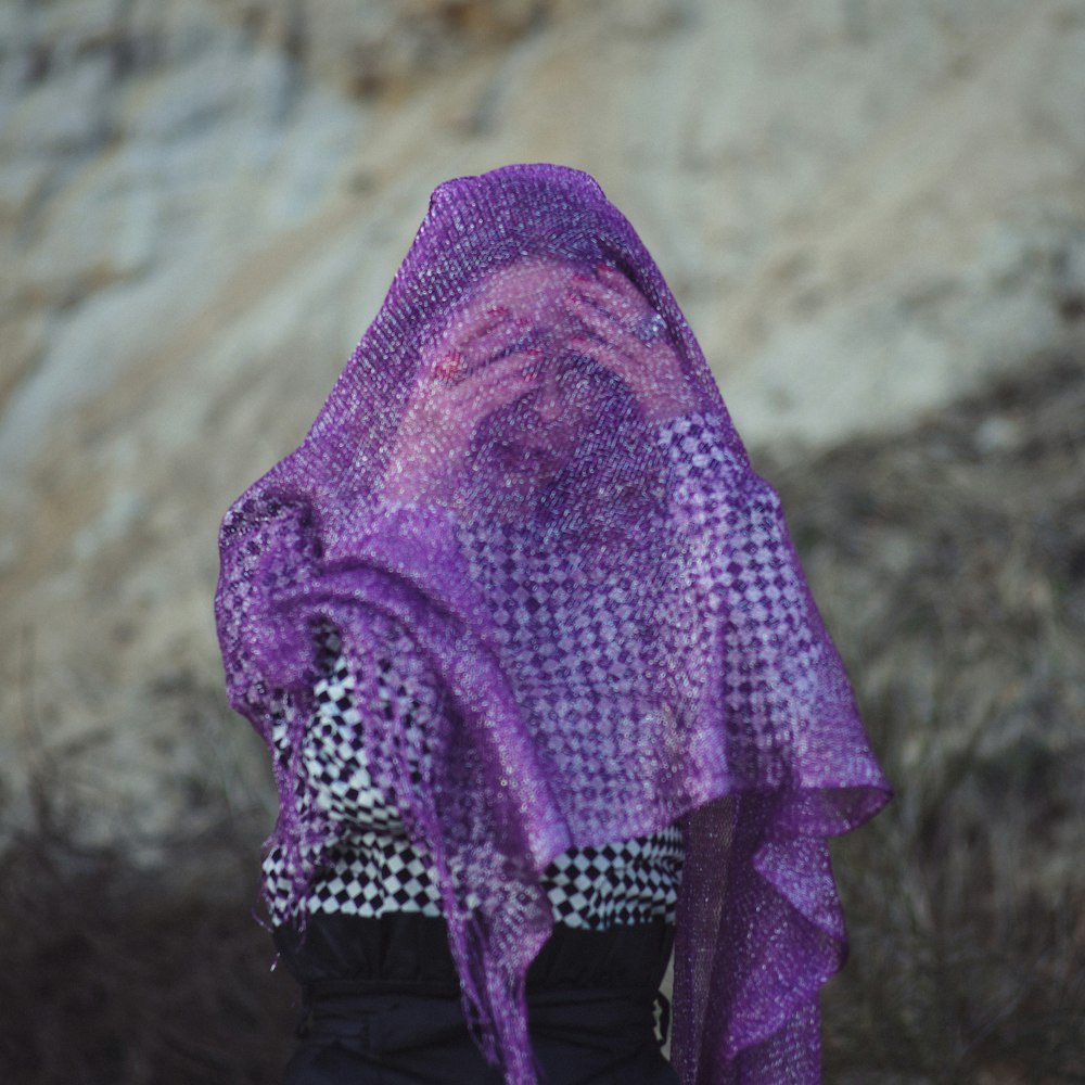 Fotografia de foco seletivo da mulher usando lenço roxo