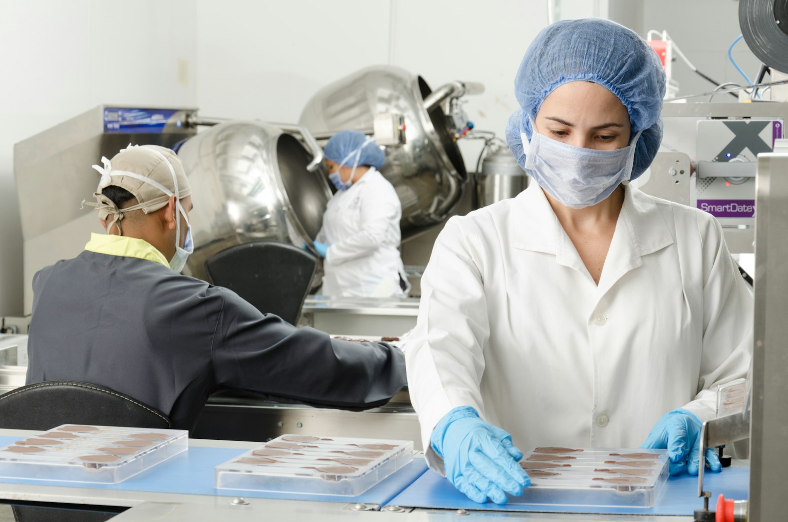 Workers in insulated coats processing meat on a cold plant production line.