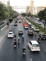 An overhead view of a busy street filled with various cars and bikes in motion.