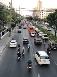 A busy urban street with various vehicles including motorcycles and cars.