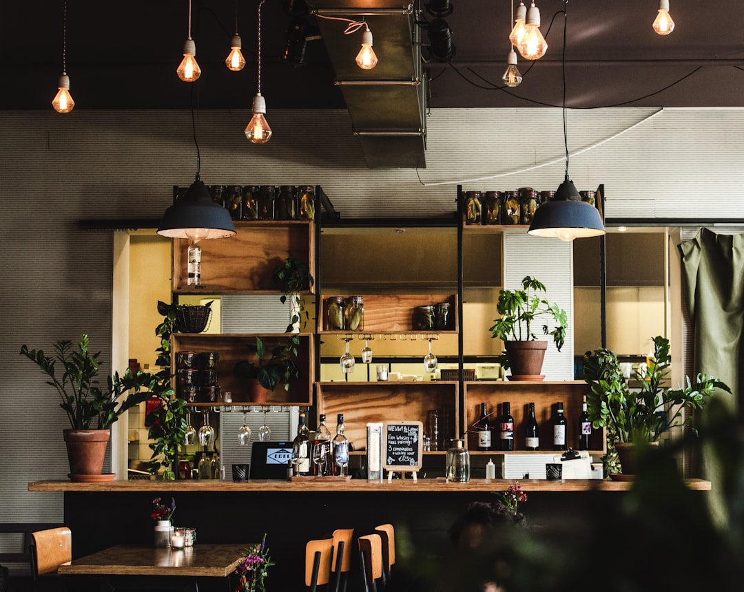a bar with lots of plants and hanging lights,