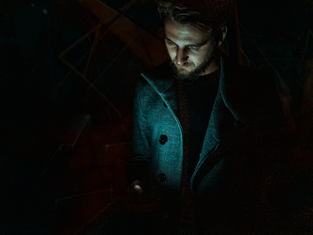 homem segurando smartphone vestindo casaco azul
