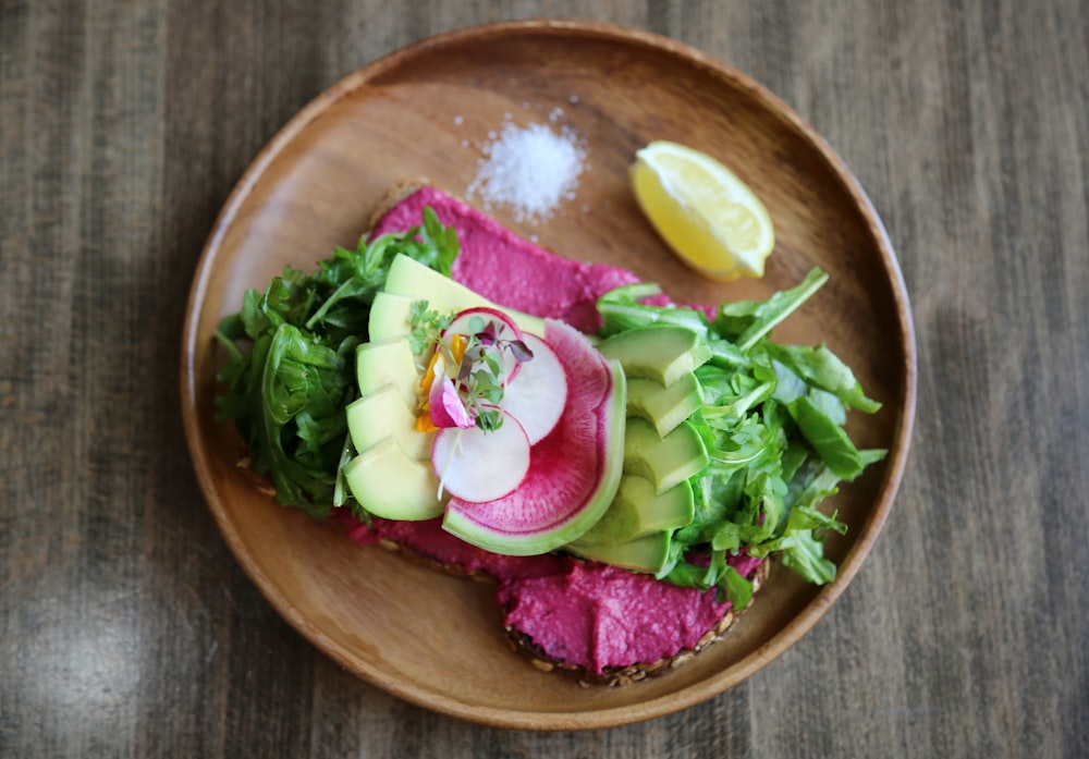 sliced cabbage, avocado and lemon on plate