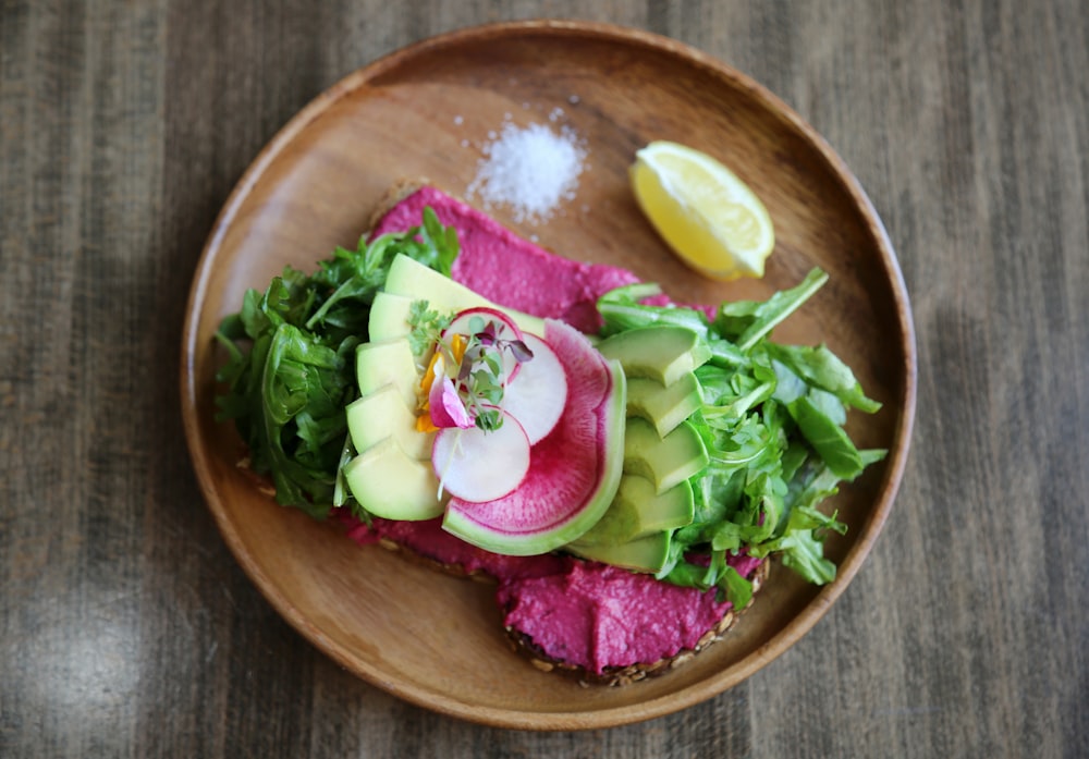 in Scheiben geschnittener Kohl, Avocado und Zitrone auf dem Teller