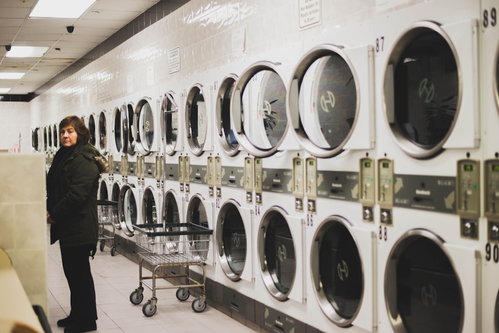 woman in black jacket near washers