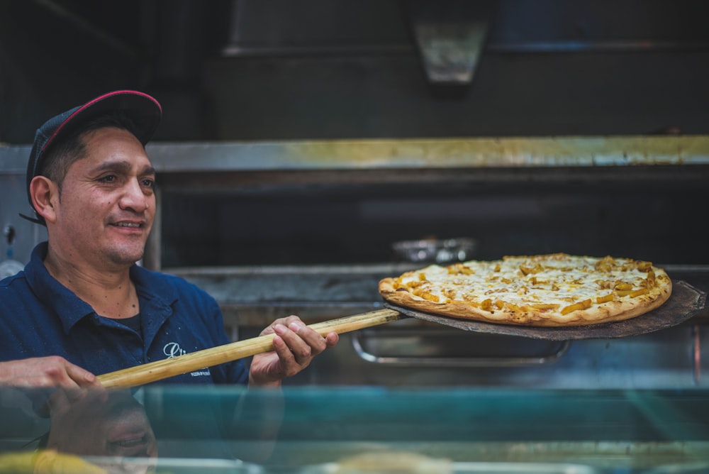 man holding pizza on holder