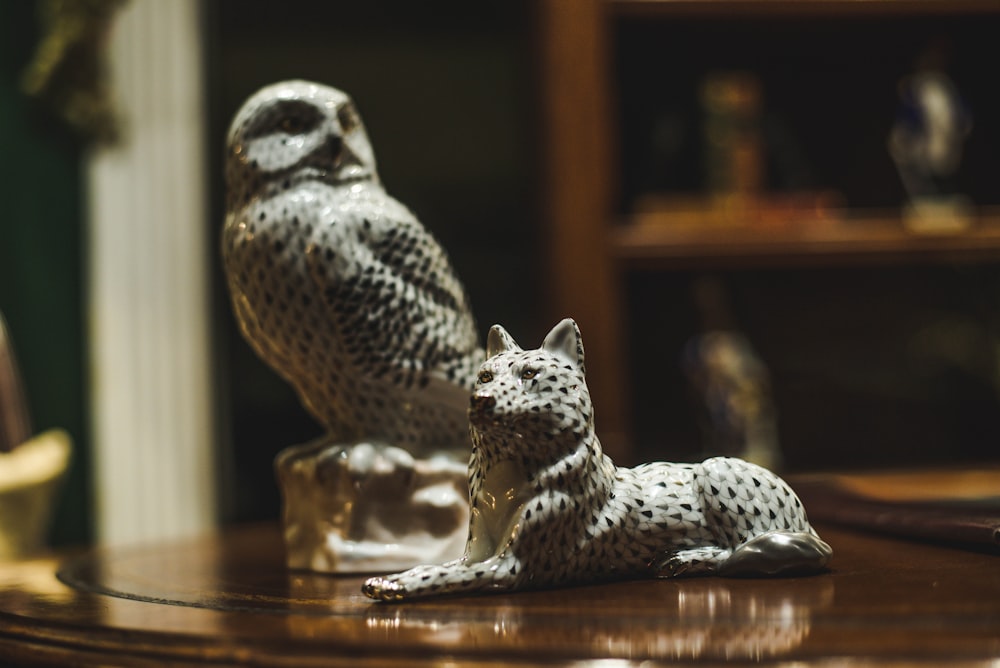 white and black owl and wolf figurines