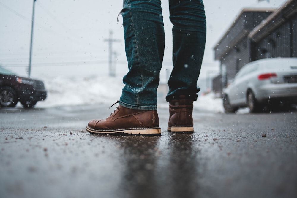 a person standing on a wet sidewalk in the snow