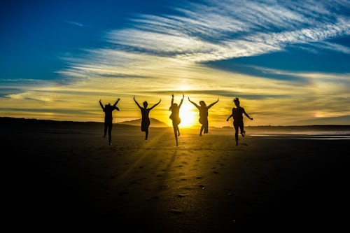 Foto van mensen die springen van vreugde op het strand, zoals het succes dat deze hulpmiddelen kunnen brengen