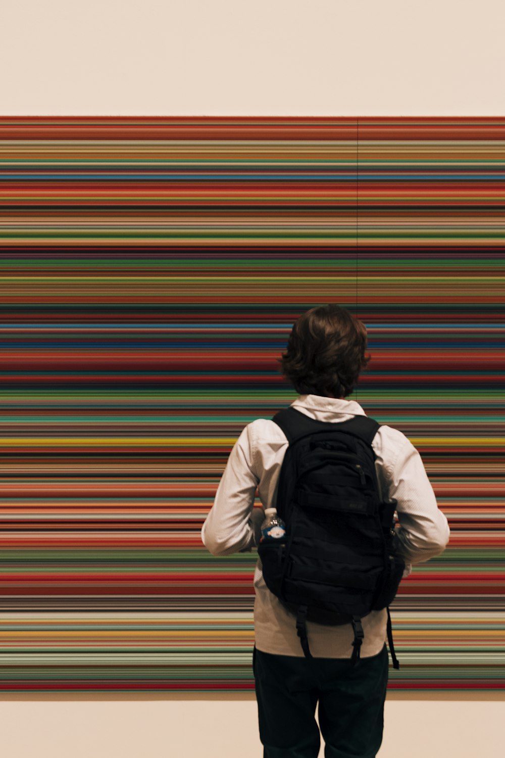 man standing on floor while wearing black backpack