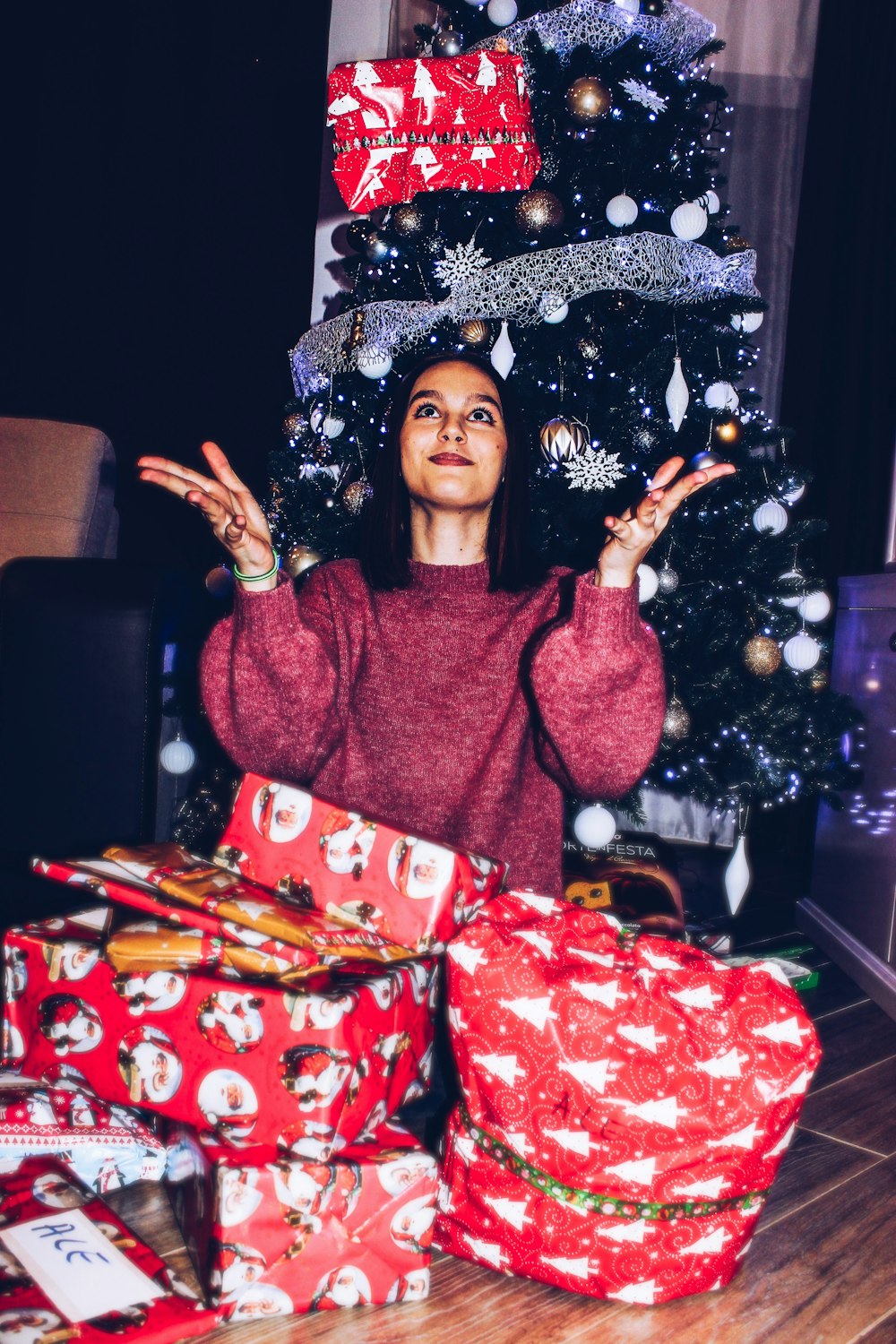 woman receives gift near Christmas tree