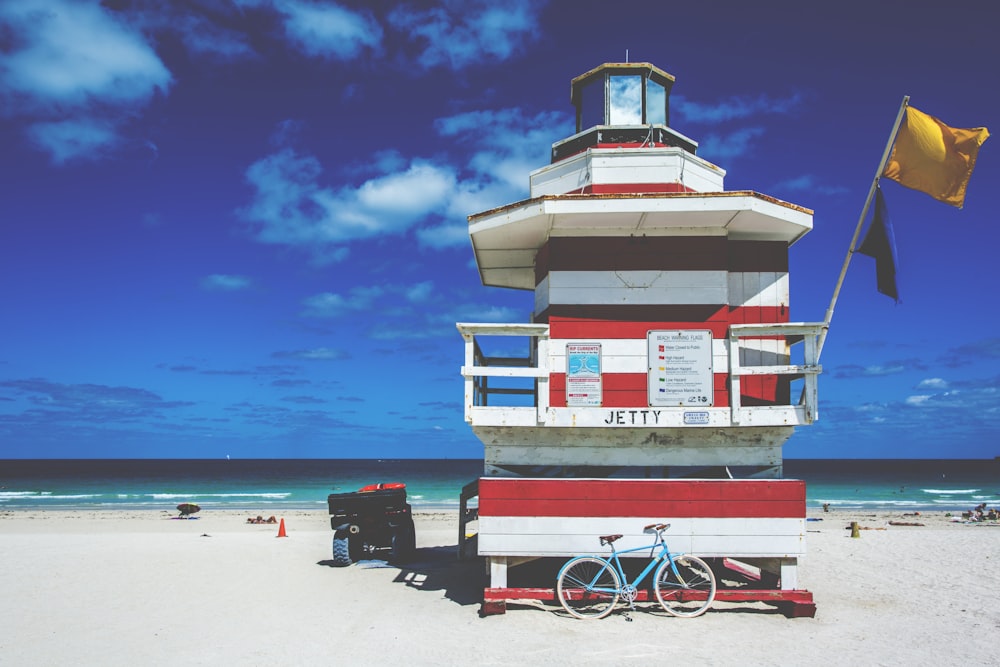 blue bike leaning beside lifeguard house