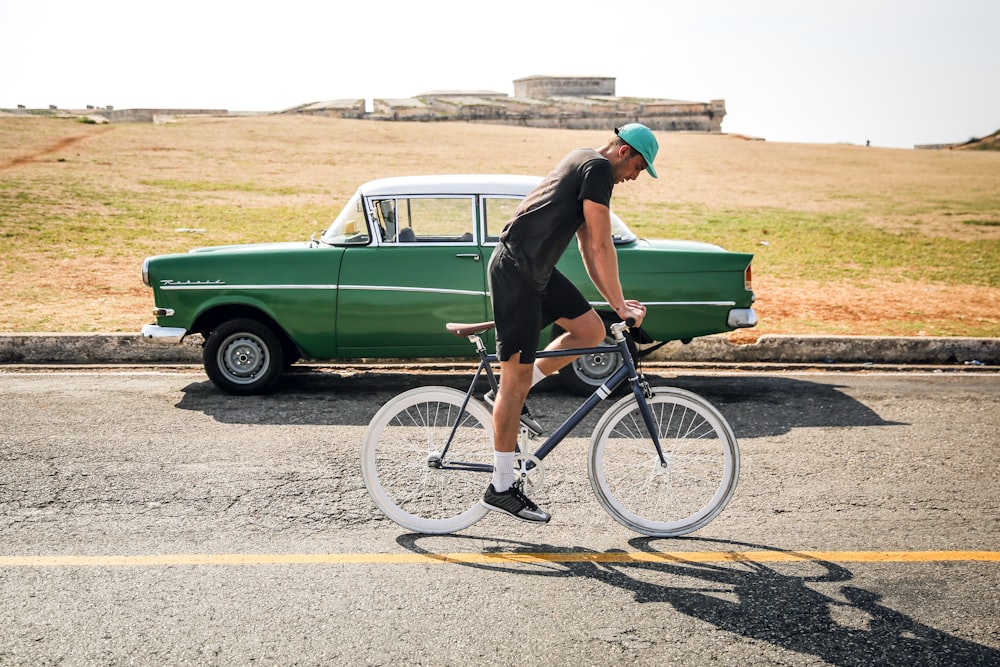 man riding on black road bike