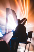 A harpist illuminated by soft golden lighting at an intimate religious ceremony.