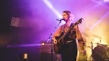 woman playing guitar while singing
