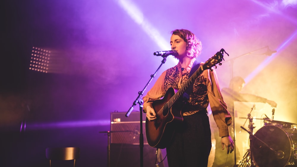 woman playing guitar while singing