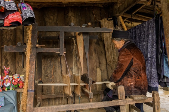 Artisan hand-weaving intricate Kaniyaro patterns on a loom in a warmly lit workshop.
