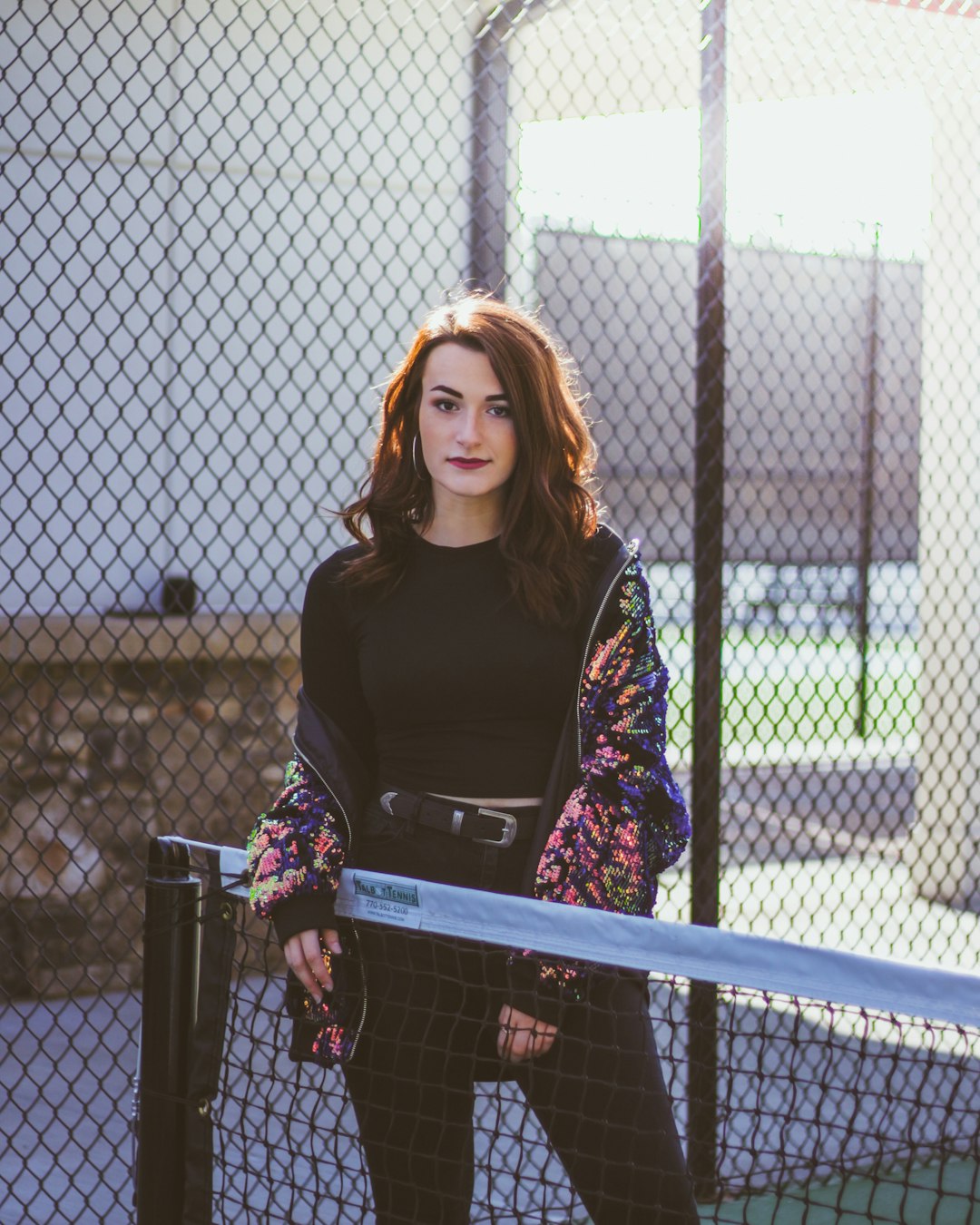 woman wearing black crew-neck shirt with pink and black flroal jacket holding net