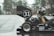 A driver wearing a helmet is seated in a small racing car with the number 31 marked on the rear wing. The car is parked on a wet pavement near a forested area, with trees visible in the background. The vehicle has logos from various sponsors including SKF, Lucas Oil, and Hoosier Tire.