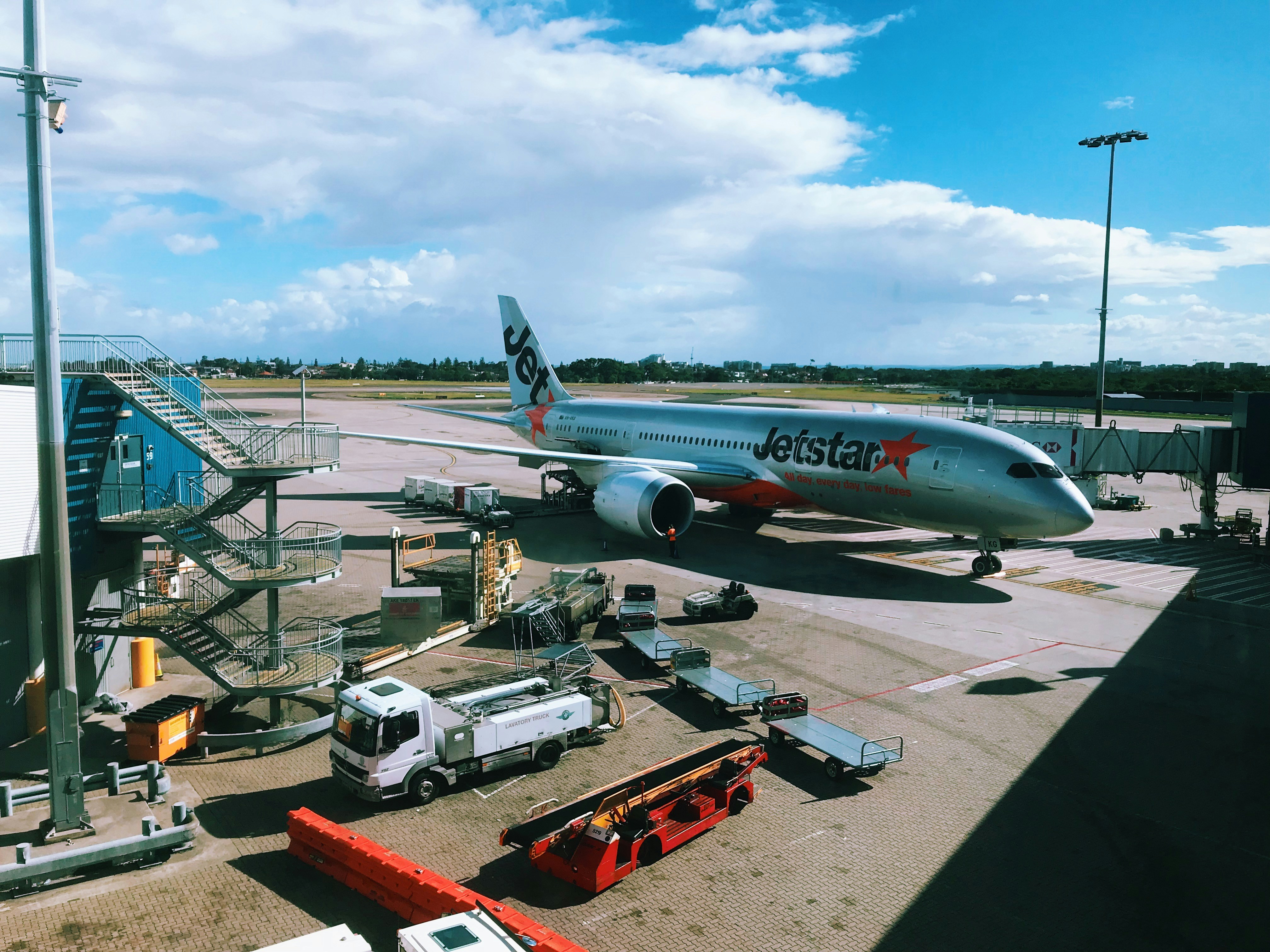gray and red JetStar airplane on parking, 