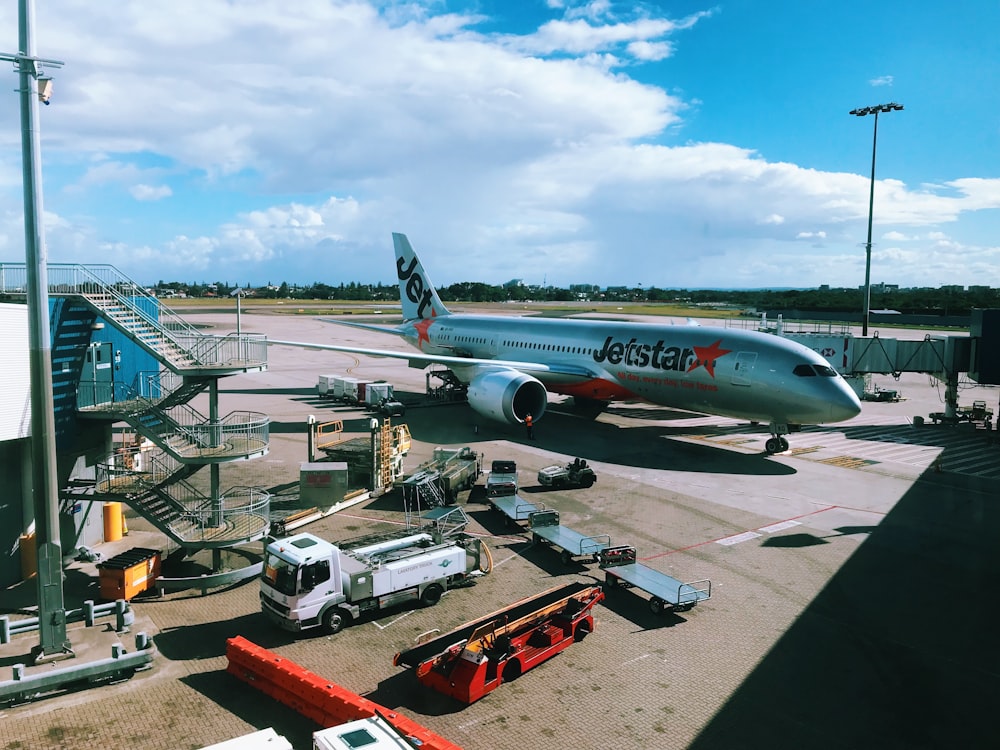 gray and red JetStar airplane on parking