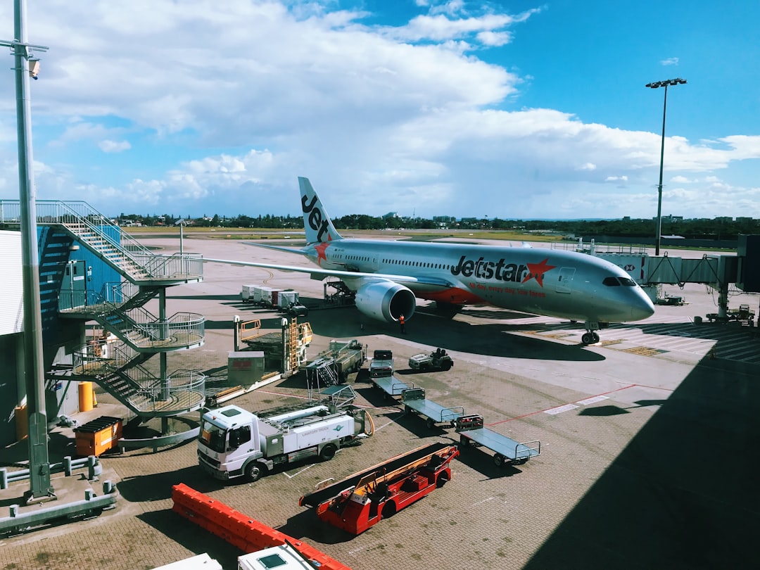 gray and red JetStar airplane on parking,