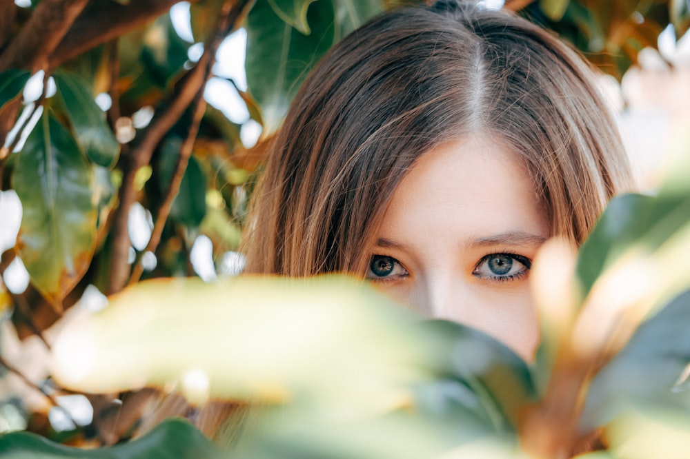 woman hiding on green plants during daytime