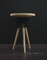 Close-up of a handcrafted wooden stool with smooth rounded edges and natural finish.