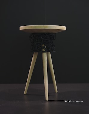 Close-up of a handcrafted wooden stool with smooth rounded edges and natural finish.