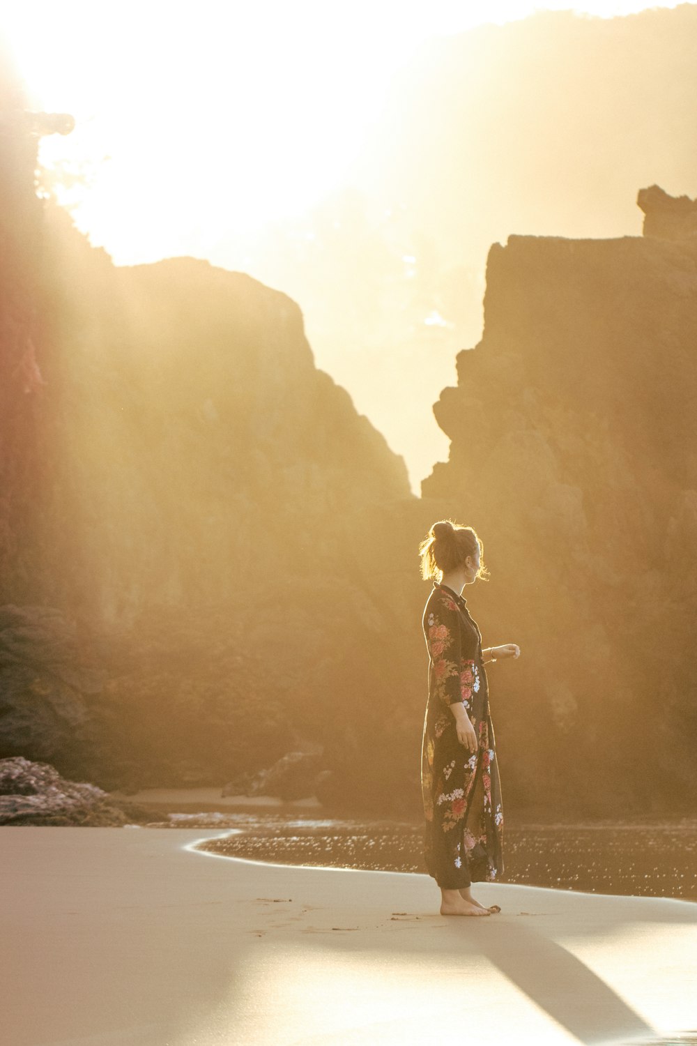 woman standing on shore during golden hour