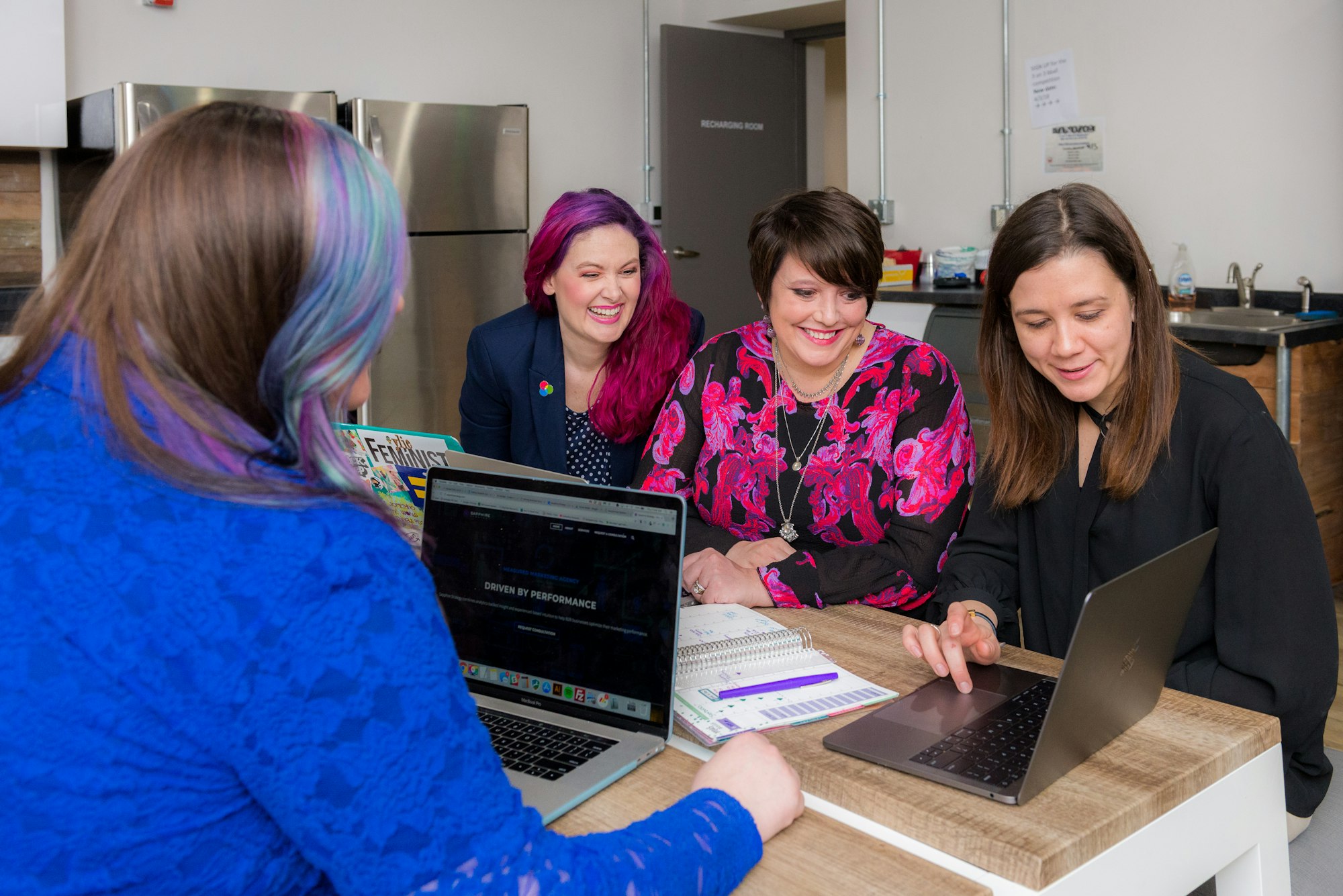 A small business employee meeting: 4 women looking at a laptop.