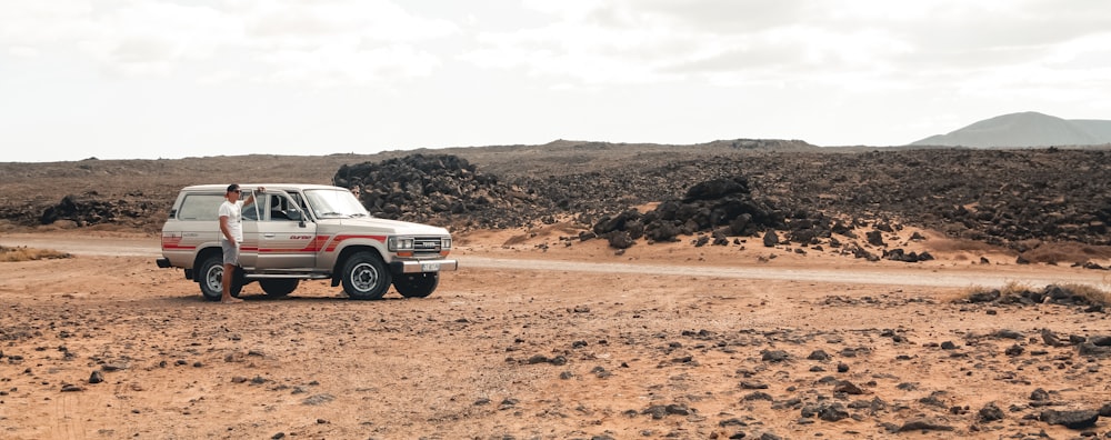 man standing beside SUV