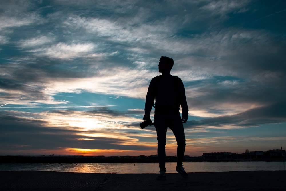 silhouette of man standing holding camera