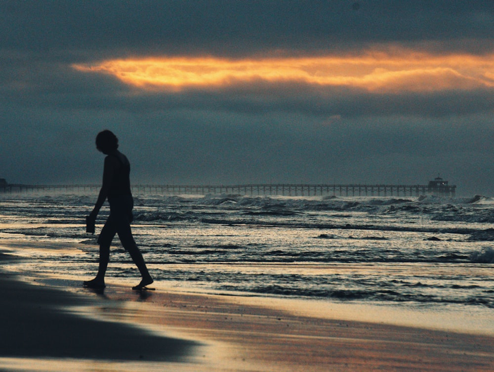 person walking on seashore