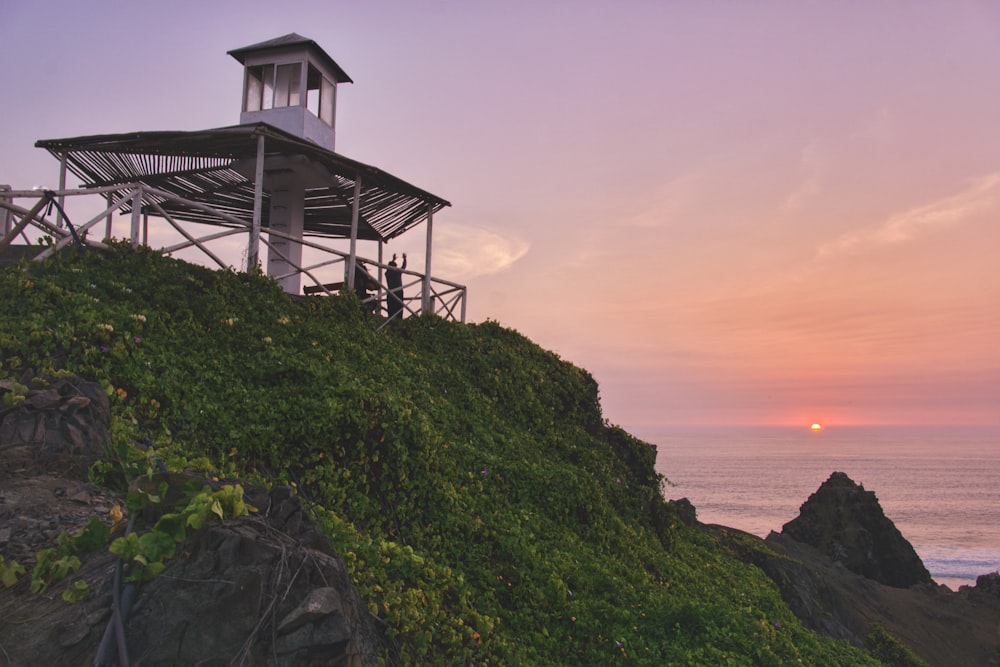 white lighthouse across sunset