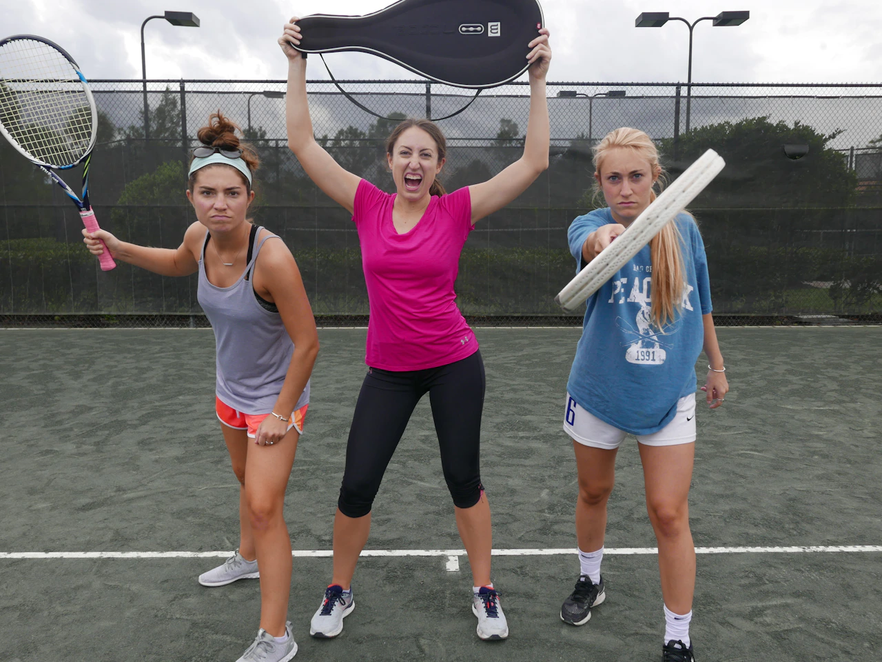 Nhóm bạn cầm vợt cười rạng rỡ trên sân tennis