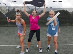 three women holding tennis rackets