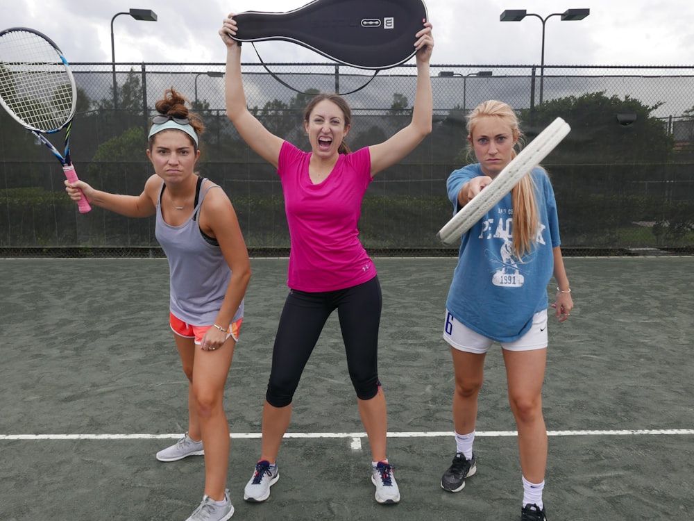 Tres mujeres sosteniendo raquetas de tenis