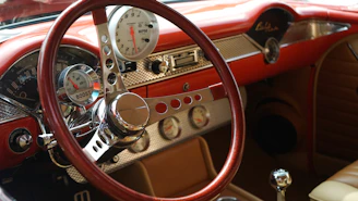 Close-up of a mid-century modern dashboard inside a classic car with warm cream and deep brown tones