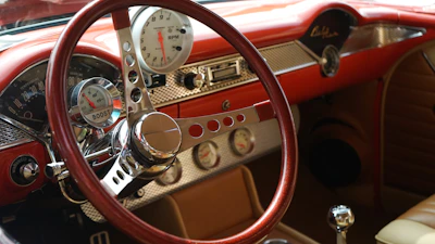 Close-up of a mid-century modern dashboard inside a classic car with warm cream and deep brown tones