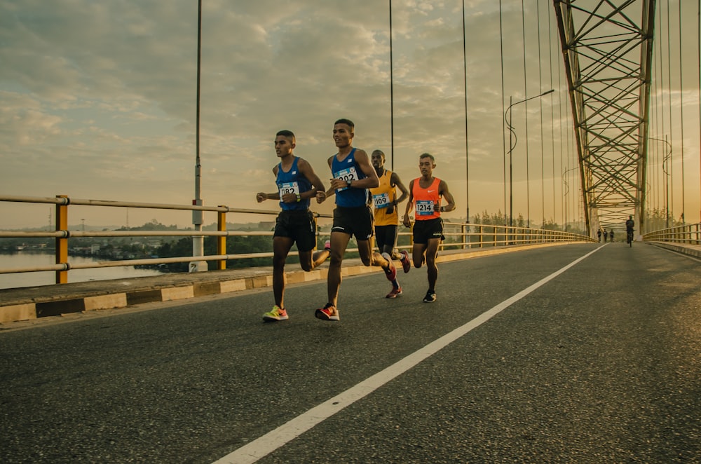 four men running on asphalt floor