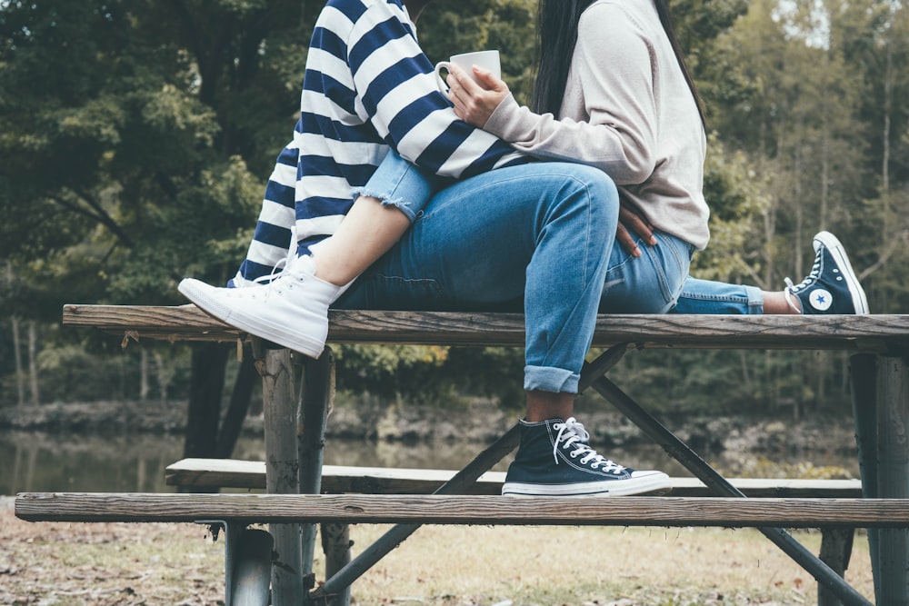 man and woman sitting on brown wooden bench