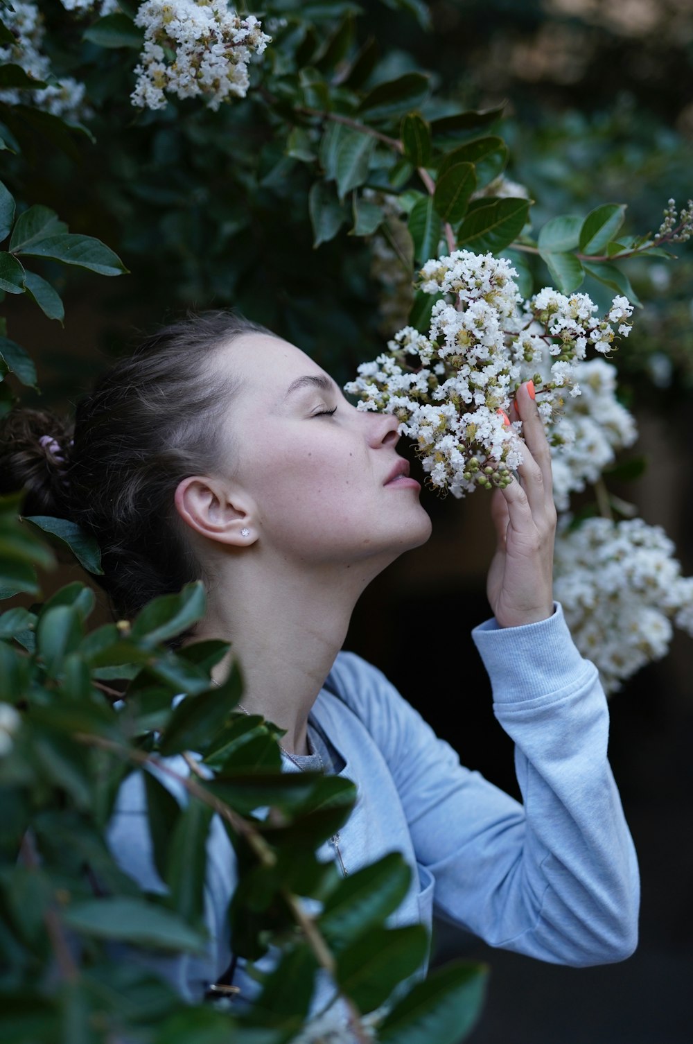 Mujer olfateando flor