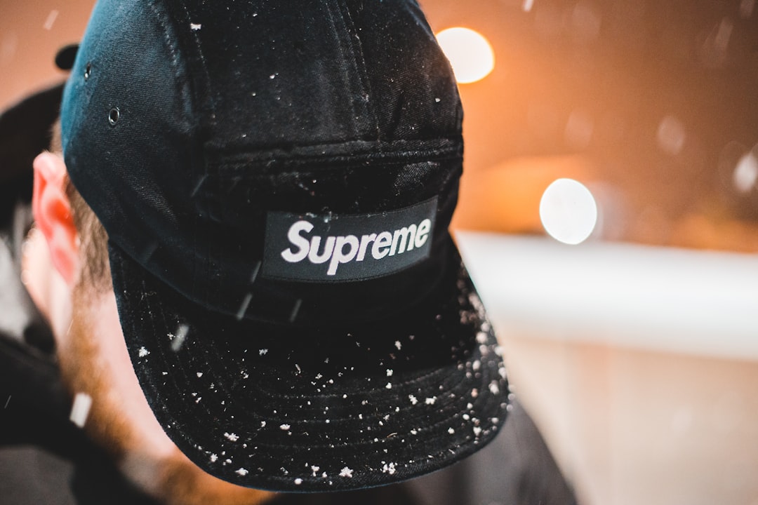 man wearing black Supreme cap